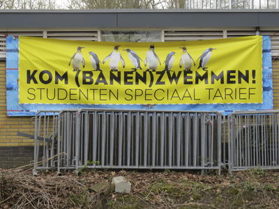 908154 Afbeelding van het spandoek met de tekst: 'KOM BANEN ZWEMMEN! / STUDENTEN SPECIAAL TARIEF', op een bijgebouw van ...